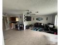 Inviting living room featuring tile flooring, ceiling fan, and view to the open-concept kitchen at 1556 Ferendina Dr, Deltona, FL 32725