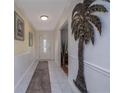 Inviting hallway with white tile flooring, decorative wall art, and a glimpse into the living spaces at 179 Ann Rustin S Dr, Ormond Beach, FL 32176