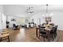 Open-concept living and dining area with modern lighting, stylish furniture, and wood flooring throughout at 185 Brookside Dr, Port Orange, FL 32128