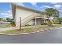 Two-story condo with a well-maintained lawn and landscaping in front of the stairway and porch at 1935 Conway Rd # A4, Orlando, FL 32812