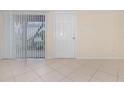Bright living room features tile flooring, vertical blinds, and a door leading to the outside area at 1935 Conway Rd # A4, Orlando, FL 32812