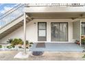This is the porch with a decorative mat, potted plants and rocks with plants near the stairway at 1935 Conway Rd # A4, Orlando, FL 32812
