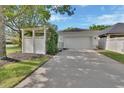 Two-car garage with spacious driveway, complemented by a white pergola, enhancing curb appeal at 202 W Chancery Ln, Deland, FL 32724