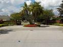 Lakeside community entrance features brick pillars, iron gates, and well-maintained landscaping at 217 Lourdan Ct, Debary, FL 32713