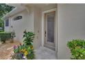 Charming front entrance boasts a decorative glass door, blooming plants, and neutral stucco at 217 Lourdan Ct, Debary, FL 32713