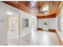 Bright living room featuring a wooden ceiling, white brick walls, and tile flooring at 220 N Julia Ave, Deland, FL 32720