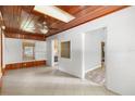 Bright living room featuring a wooden ceiling, white brick walls, and tile flooring at 220 N Julia Ave, Deland, FL 32720