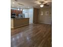 Open-concept living space with modern laminate flooring flowing into the kitchen and dining area at 223 W Fiesta Key Loop, Deland, FL 32720