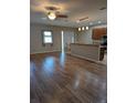 Bright and airy living area with laminate flooring, leading to the kitchen and a sliding glass door at 223 W Fiesta Key Loop, Deland, FL 32720