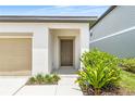 Inviting front entrance featuring a neutral-toned door, a covered porch, and lush landscaping at 2241 Litchfield Loop, Deland, FL 32720