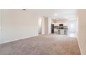 Spacious living room with neutral carpet, flowing into an open-concept kitchen with breakfast bar seating at 2241 Litchfield Loop, Deland, FL 32720