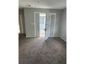This is an empty room with gray walls, carpet and double doors that open to the outside at 2366 Florida Dr, Deltona, FL 32738