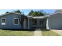 The front exterior of this house shows a gray house with a tree in front and a walkway at 2366 Florida Dr, Deltona, FL 32738
