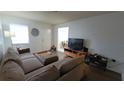 Comfortable living room with neutral tones, featuring a sectional sofa and laminate flooring at 2380 Spring Hollow Drive, Orange City, FL 32763