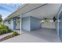 View of the carport showing access to the front door with tidy landscaping at 2720 Kumquat Dr, Edgewater, FL 32141