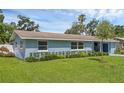 A light blue single-story house features tidy landscaping and a lush green lawn at 2720 Kumquat Dr, Edgewater, FL 32141