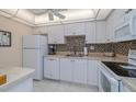 Well-lit kitchen with white cabinets, tiled backsplash, and modern appliances at 2800 N Atlantic Ave # 1716, Daytona Beach, FL 32118