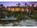 Beachfront home at dusk features a private wooden deck and beach access via stairs at 2833 S Atlantic Ave, Daytona Beach, FL 32118
