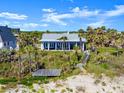 Charming beachfront house with a wooden walkway leading to a dock and a deck at 2833 S Atlantic Ave, Daytona Beach, FL 32118