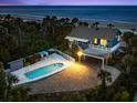 Aerial dusk view of an estate featuring a backyard pool, covered parking, and beach access at 2833 S Atlantic Ave, Daytona Beach, FL 32118