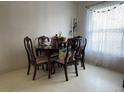Cozy dining room featuring a wooden table with chairs and natural light streaming through the window at 2875 Delrose N Dr, Lakeland, FL 33805