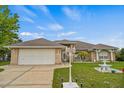 Charming single-Gathering home featuring a well-manicured lawn, complemented by a decorative fountain and brick facade at 2880 Boyd Ct, Deltona, FL 32738