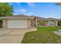 Beautiful single-story home with a well-maintained lawn, lush landscaping, and a two-car garage at 2880 Boyd Ct, Deltona, FL 32738