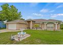 Beautiful single-story home with a well-maintained lawn, lush landscaping, and a two-car garage at 2880 Boyd Ct, Deltona, FL 32738