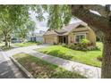 Attractive curb appeal with a manicured lawn, mature landscaping, and a charming single story residence at 307 Ravenshill Way, Deland, FL 32724