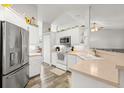 Bright kitchen with white cabinetry, stainless steel appliances, and ample counter space for meal preparation at 3132 Mango Tree Dr, Edgewater, FL 32141