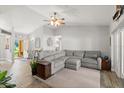 Spacious living room featuring vaulted ceilings, wood flooring, a ceiling fan, and an inviting gray sectional at 3132 Mango Tree Dr, Edgewater, FL 32141