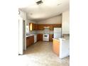 Functional kitchen with wood cabinets, tile floor, and white appliances at 3155 Mapleshade St, Deltona, FL 32738
