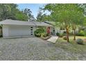 Charming home featuring a red front door, gravel driveway, and tidy landscaping at 319 N Salisbury Ave, Deland, FL 32720