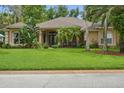 Inviting single-story home with lush green lawn and tropical landscaping, creating curb appeal at 33 Coquina Ridge Way, Ormond Beach, FL 32174