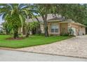 Well-maintained one-story home with mature landscaping, brick driveway, and a welcoming appearance at 33 Coquina Ridge Way, Ormond Beach, FL 32174