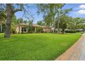 Expansive green lawn and mature landscaping surrounding a charming single-story home at 33 Coquina Ridge Way, Ormond Beach, FL 32174
