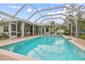 Large screened in pool with an outdoor seating area and mature landscaping at 3671 Plantation Dr, Ormond Beach, FL 32174