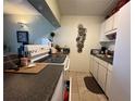 Functional kitchen featuring white appliances and dark countertops at 411 N Halifax Ave # 208, Daytona Beach, FL 32118