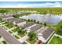 Aerial view of the neighborhood showcasing the lake with a fountain and mature trees at 422 Armoyan Way, New Smyrna Beach, FL 32168