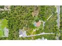 Expansive aerial view of a private estate featuring a pool, surrounded by lush greenery and secluded landscaping at 43350 Natchez St, Deland, FL 32720