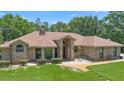 Inviting brick home with a well-maintained lawn, showcasing a welcoming entrance and charming curb appeal at 43350 Natchez St, Deland, FL 32720