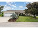 Charming single-story home boasts a two-car garage and well-manicured lawn with mature landscaping at 5445 Turton Ln, Port Orange, FL 32127