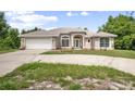 Single-story home featuring an attached garage, circular driveway, and well-maintained lawn at 570 Cypress Ave, Orange City, FL 32763