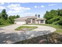 Charming single-story home with a circular driveway, attached garage, and lawn at 570 Cypress Ave, Orange City, FL 32763
