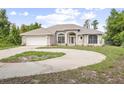 Charming single-story home with a circular driveway, attached garage, and manicured lawn at 570 Cypress Ave, Orange City, FL 32763