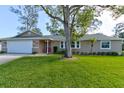 Charming single Gathering home featuring a large front yard and a two-car garage at 65 Sycamore Cir, Ormond Beach, FL 32174