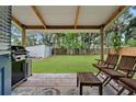 Outdoor deck with seating overlooks a spacious backyard with lush greenery and a storage shed at 832 Donnelly Pl, Daytona Beach, FL 32114