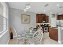 Cozy dining area featuring modern lighting, a glass-top table, and neutral wall paint at 893 Assembly Ct, Reunion, FL 34747