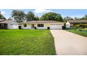 Well-maintained yellow home with an attached garage and neatly trimmed front yard at 952 N Fairbairn Dr, Deltona, FL 32725
