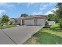 Inviting single-story home with a large driveway and an attached three-car garage at 1018 River Falls Cir, Deland, FL 32720